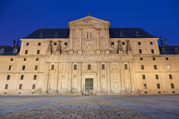 El Escorial, Spain - December 15, 2012: Main facade of Royal Monastery of San Lorenzo de El Escorial illuminated at night, Nobody visible.  UNESCO World Heritage Site