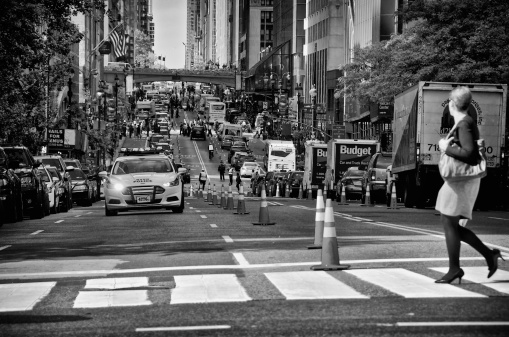 New York City, USA - September 25, 2013: A pedestrian looks at a NYPD - New York Police Department police car escorting diplomats along 42nd St. in Midtown Manhattan during the United Nations General Assembly.