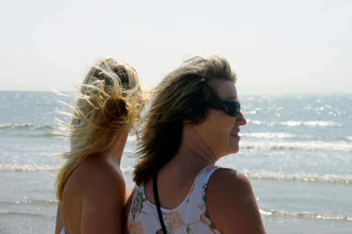 IJmuiden, the Netherlands,- June 02, 2011 : Mother and daughter  are walking on the beach in the afternoon sun, enjoying the warm weather at the Ijmuiden beach of the North sea.