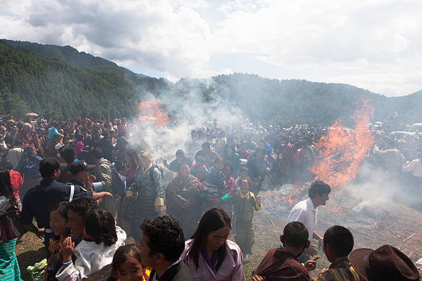 Village people jump through two burning haystacks at Thangbi festival stock photo