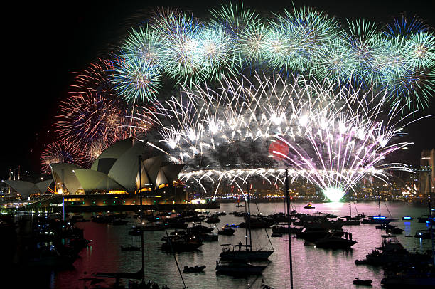 Sydney, Australia - January 1, 2011: Sydney New Year Fireworks over Sydney Harbour with reflections on water and fireworks on bridge.