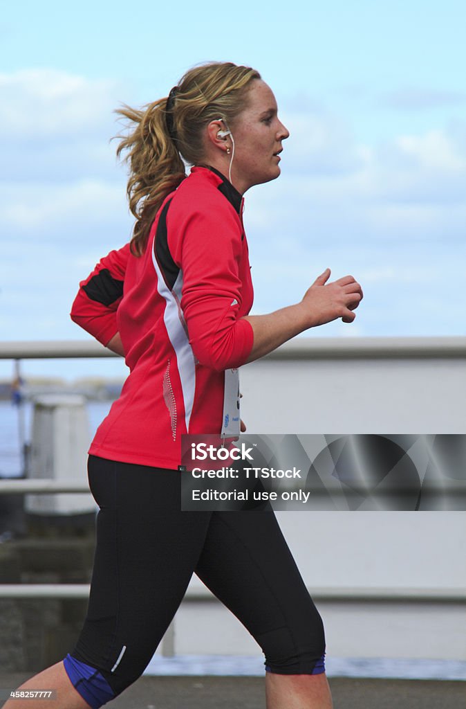 Runner dressed in pink Dordrecht, The Netherlands - April 1, 2012: The 65th edition of aEDwars door Dortaa race held in the old centre of the town. Female runner dressed in pink listening to music in the 10km race. Active Lifestyle Stock Photo