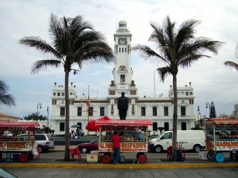 Veracruz, Mexico - March 25, 2006: lighthouse and Veracruz port promenade. Locals at their ambulant stalls selling shave ice (raspados)