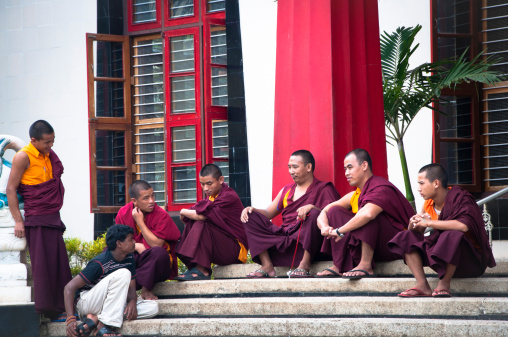 Bylakuppe, India - August 7, 2010: Group of buddhist monks deliver a teaching session to a commoner