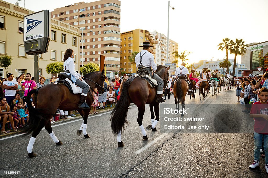 Riders on Horses in Andalusian Spring Parade Algeciras, Spain - June 16, 2012: Crowds line the Paseo Maritimo in Algeciras, Spain watching horses with riders wearing traditional clothing in a parade marking the beginning of the annual Spring Fair. The Algeciras Fair (Spanish: Feria de Algeciras) is held in the Andalusian city of Algeciras, Spain. The fair generally begins in the third week of June and lasts for one week. Andalusia Stock Photo