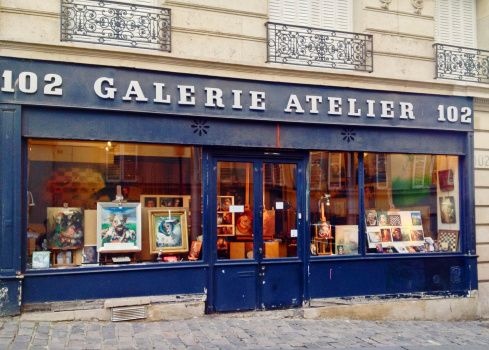 Paris France - December 25, 2012: Galerie Atelier 102 Entrance with many paintings on window display, Paris, located at Montmartre