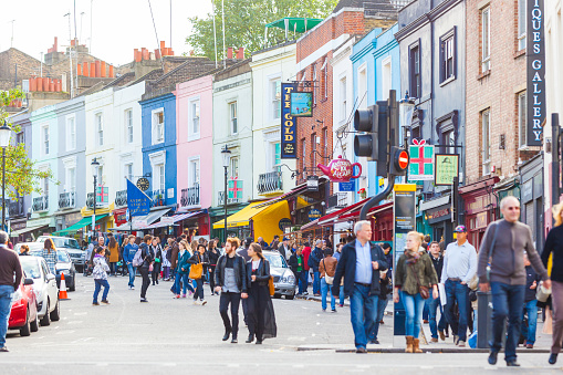 London, United Kingdom - October 27, 2013: Tourists in Portobello Road, a famous market area in Notting Hill district