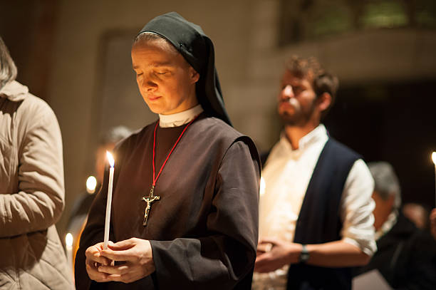 catholic suora pregare con candela - nun foto e immagini stock