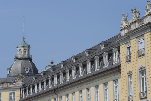 Karlsruhe, Germany - July 10, 2013: Architectural detail of he palace in Karlsruhe, Germany, in bright sunshine. Originally constructed in 1715 the palace is located in the city center with over 30 city streets radiating out from it.