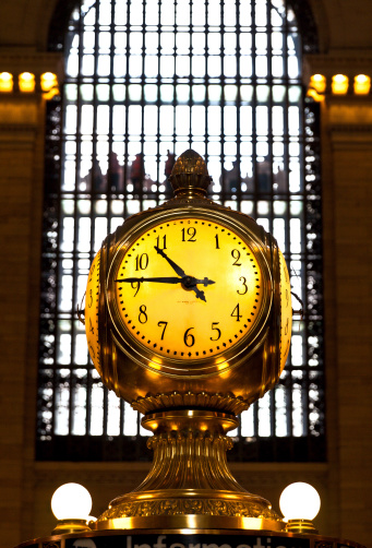 New York, USA - May 7, 2013 : Grand Central Station clock in New York. The Grand Central is famous for a lot of films and this clock is world known for that. It shows 10:45 in the morning in a cloudy day with lots of passengers and tourist walking around.