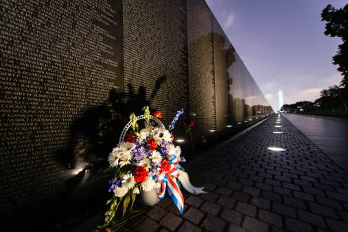 Washington, DC. USA - June 18, 2013: A flower bouquet in front of the Vietnam Veteran's Memorial with a view of the Washington Monument in the background.