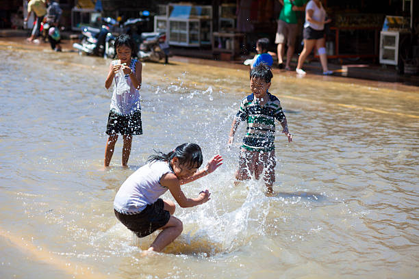 crianças brincam em em época, siem reap, camboja - flood people asia cambodia - fotografias e filmes do acervo