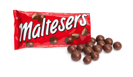 Taipei, Taiwan - December 17, 2012: This is a studio shot of an open bag of Maltesers chocolate candy made by Mars Inc. isolated on a white background.