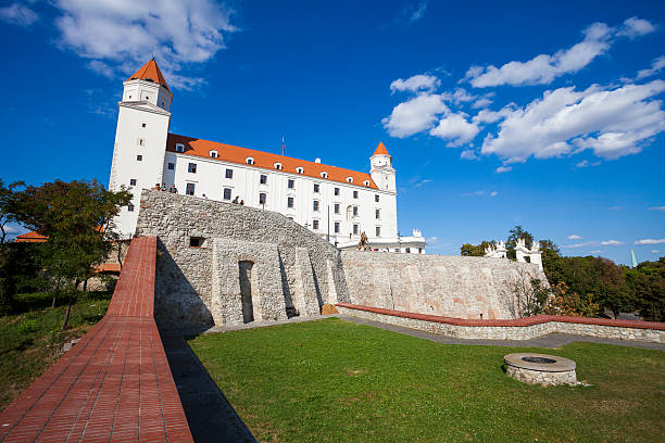 Bratislava castle, Slovakia Bratislava, Slovakia - September 12, 2011: Low angle view of Bratislava castle which occupies a prominent location in the city overlooking the Danube river. People can be seen on the edge of a wall looking out and enjoying the view. bratislava castle bratislava castle fort stock pictures, royalty-free photos & images