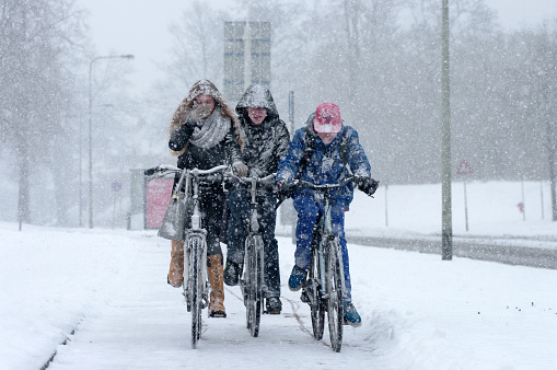 Brunssum, the Netherlands - March 14, 2013 : Extreme snowfall in the late winter. Bikers trying to get forward on the road. The after winter in Limburg and waiting for spring.