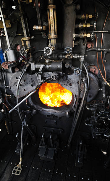 Durango and Silverton Narrow Gauge Railroad Silverton, United States - June 16, 2013: On the footplate of locomotive No. 482 of the Durango and Silverton Narrow Gauge Railroad at Silverton, Colorado, USA. The firebox doors are open, waiting for another shovelful of coal. No, 482 is one of the K-36 class Mikado 2-8-2 steam locomotives designed for the D&RGW (Denver & Rio Grande Western) and built by the Baldwin Locomotive Works in 1925. It hauls steam trains over the railroad which now operates as a tourist attraction carrying passengers over the 45 miles of 3 ft gauge track between Silverton and Durango. firebox steam engine part stock pictures, royalty-free photos & images