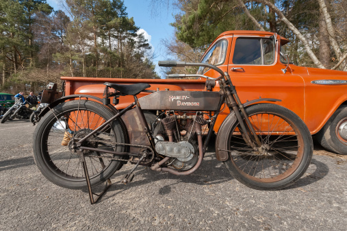 Farnborough, UK - March 29, 2013: Vintage Harley Davidson motorcycle, circa 1920, and a Chevy pick-up truck on display at the annual Wheels Day auto and bike festival. The event attracts over 1000 publically owned vehicles.