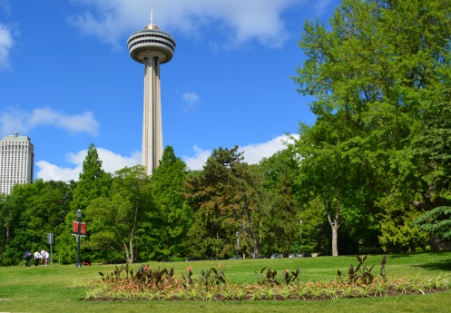 Niagara Falls Ontario, Canada - June 03, 2013: group of unnamed female tourists walking along River Road, Skylon tower and the Falls View Casino in the background