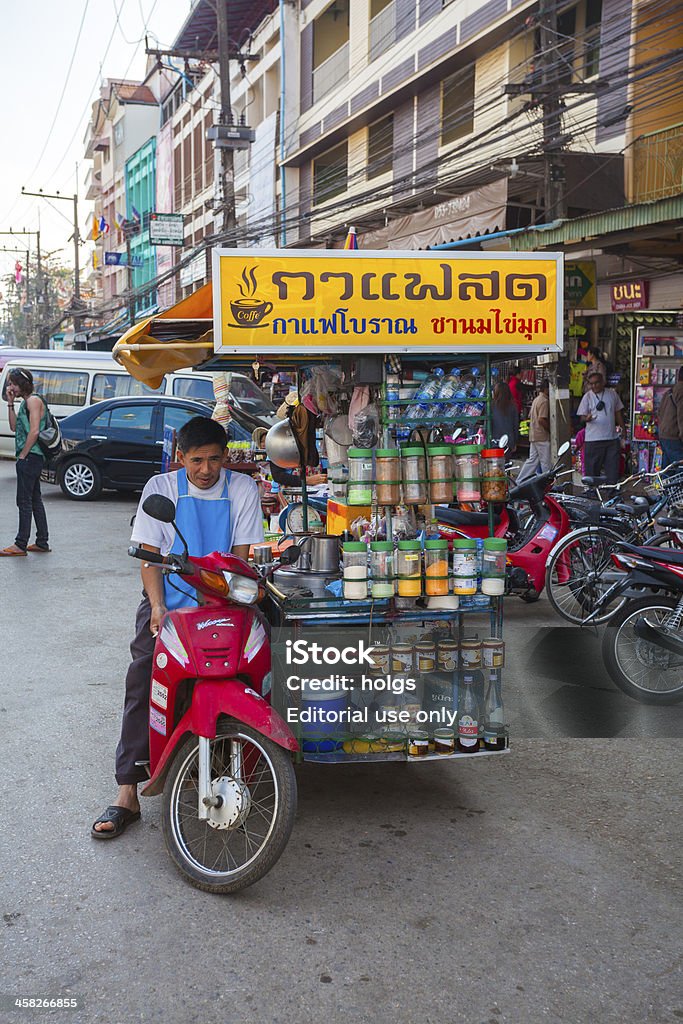 Mai Sai Food Vendor, Thailand Mae Sai, Thailand - December 13, 2011: Man can be seen sitting on a motorised food stall that sells Thai Iced Tea and coffee on the side of the street in Mae Sai, a town on the Thai - Myanmar border in northern Thailand. People can also be seen in the background. Asia Stock Photo