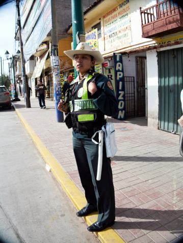 Arequipa, Peru - June 1, 2013: Female traffic policewoman on duty in Cuzco city centre on a sunlit sidewalk
