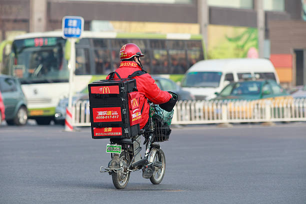 livraison de mcdonald sur un e-bike à pékin - mcdonalds french fries branding sign photos et images de collection