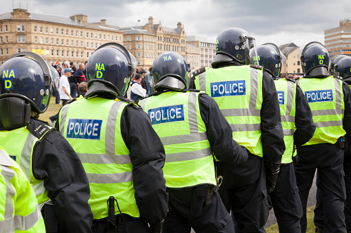 Bradford, UK - August 28, 2010: Police in riot gear form a line to contain protestors at the English Defence League rally in Bradford. The EDL, a far right group, held a rally in the city of Bradford which has a large Muslim polulation.