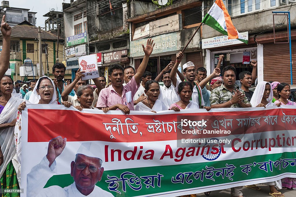 Anti-corruption march is support of Anna Hazare, Jorhat, India. Jorhat, India - August 23, 2011: An anti-corruption march by supporters of the popular Indian politician, Anna Hazare. The supporters are marching with a large banner and waving the Indian tri-colour flag through the main high street in the city of Jorhat in Assam, north east India. Politics Stock Photo