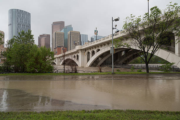 nœud aux éclaboussures ses rives à centre street bridge - calgary bridge flood alberta photos et images de collection