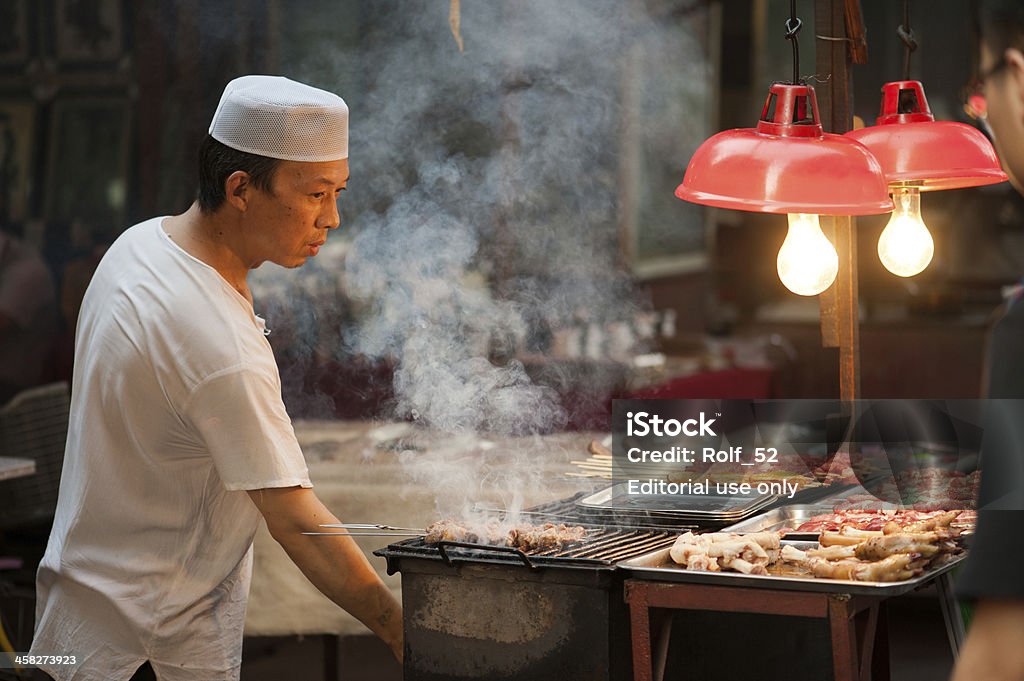Homme des grillades de mouton Hui sur des brochettes de la rue Musulmane - Photo de Chef cuisinier libre de droits