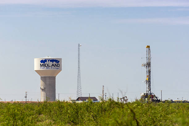 pozo de petróleo torre perforadora y torre de agua en midland en texas - oil industry oil field freight transportation oil rig fotografías e imágenes de stock