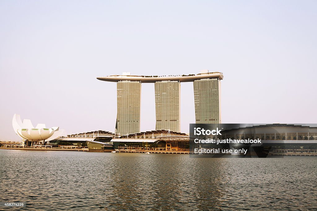 Marina Bay Sands and Arts & Science museum Singapore, Singapore - September, 3rd 2012: View over Bayfront from one promenade to other with huge hotel and landmark Marina Bay Sands. At left side is Ats & Science museum in scape of lotus flower. Along promenade is huge shopping mall. Architecture Stock Photo