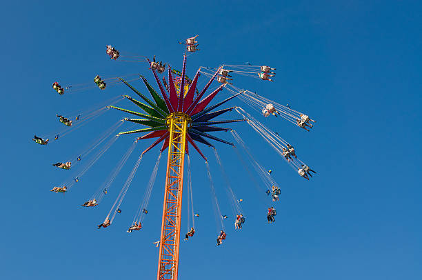 People riding High Chairoplane at German Fun Fair Cranger Kirmes stock photo