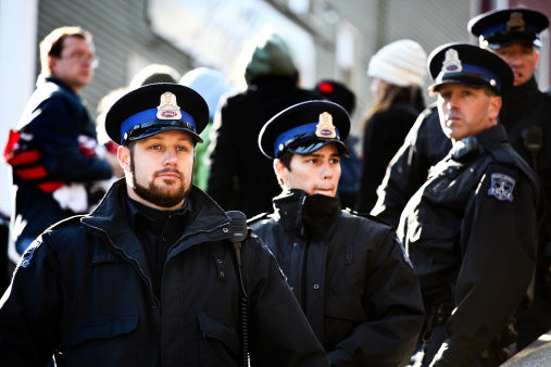 Halifax, Nova Scotia, A!anada - November 12, 2011: A group of Halifax Regional Police Officers standing watch over a Rally that was part of the Occupy Nova Scotia protests at Grand Parade Square in the downtown district of Halifax, Nova Scotia on a pleasant fall afternoon.