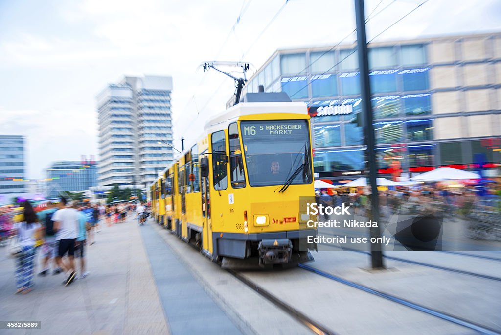 Yellow tram on the Alexanderplatz Berlin, Germany - August 7, 2013: Yellow tram crossing the Alexanderplatz, blurred People walking along tram railways. Activity Stock Photo