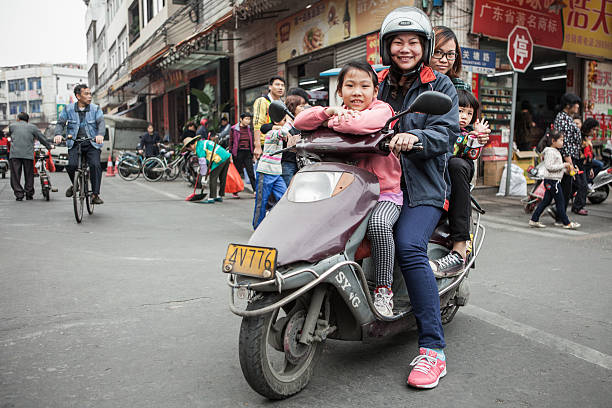 quatre personnes sur un scooter de la chine - runabout photos et images de collection