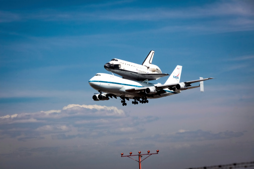 Los Angeles, California, USA - September 21, 2012: Space Shuttle Endeavor makes its final landing at noon at Los Angeles International Airport (LAX), marking an end to the space vehicle's aviation career. The shuttle is carried by a custom 747 designed by NASA to transport the shuttle from airport to airport.