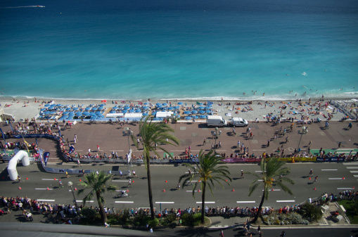 Nice, France- June 22, 2013:  aerial view of the promenade des anglais with athletes running the marathon fraction during the ironman race.Ironman is the toughest discipline in modern triathlon.