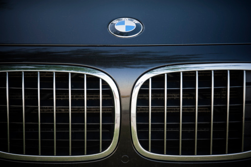 Padua, Italy - July 8, 2012: Circle shape BMW logo and part of the front grill on a black BMW (7 Series) car. BMW (Bayerische Motoren Werke) is a German automobile, motorcycle and engine manufacturing company founded in 1916. Shot in a public parking in Padua, Italy.