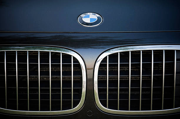 BMW Padua, Italy - July 8, 2012: Circle shape BMW logo and part of the front grill on a black BMW (7 Series) car. BMW (Bayerische Motoren Werke) is a German automobile, motorcycle and engine manufacturing company founded in 1916. Shot in a public parking in Padua, Italy. bmw stock pictures, royalty-free photos & images