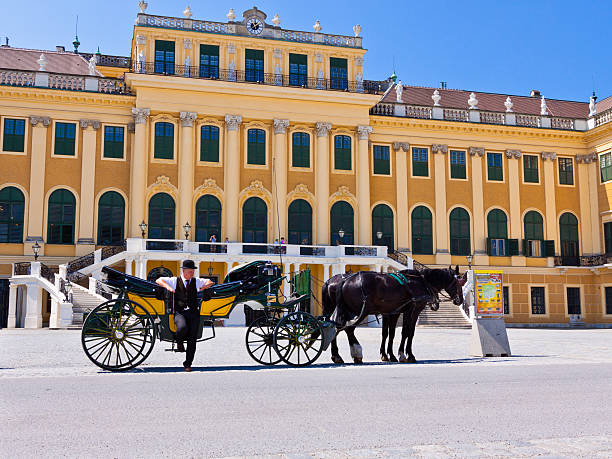 Vienna, Austria - June 22, 2013: The SchAnbrunn Palace. It was an imperial summer residence of the Habsburg monarchs. It is one of the most important cultural monuments in the country and since the 1960s it has been one of the major tourist attractions in Vienna. Horsedrawn carriage is waiting for tourists. Tourists are taking pictures and walking around.