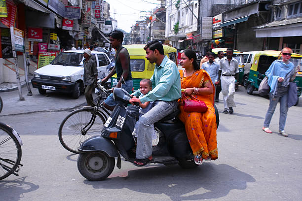 New Delhi, India - January 6, 2007: Early in the morning, pedestrians, automobiles, motorbikes, bicycles waiting at a crossroad before moving on.