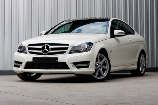 ChiangMai,Thailand - July 29, 2012: A photo of a parked White 2012 MERCEDES-BENZ C-CLASS C180 1.8 COUPE on display outside of a car dealership in Thailand,The roof is pretty curvy-line. C180 activates one of the best in automotive engineering and design,C180 is a smaller version of Mercedes-Benz and also very effective in saving fuel.