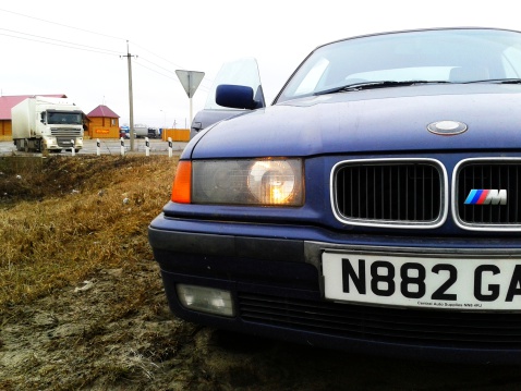 Cape Town, South Africa - February 5, 2023: A well-preserved late-1990s Mercedes-Benz 230K Sport in deep metallic maroon, parked in a street in a wealthy suburb of Cape Town, South Africa.