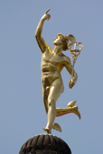 Stuttgart, Germany - June 30, 2012: The gilt statue of the Roman God Mercury made by the German sculptor Johann Ludwig von Hofer in 1862, on top of the Old Chancellary Building in Stuttgart, Germany.