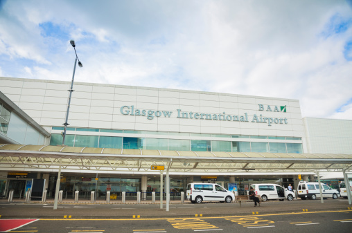 Glasgow, UK - August 13, 2013: Arriving passengers and taxis outside the main terminal of Glasgow Airport. Glasgow Airport is operated by Heathrow Airport Holdings, previously known as British Airports Authority.