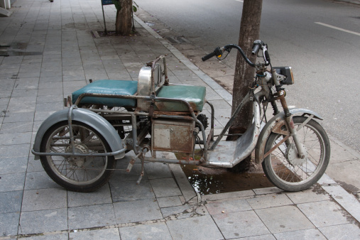 Hanoi, Vietnam: June 8, 2012: A strange old motorbike parked on the pavement in Hanoi, Vietnam.