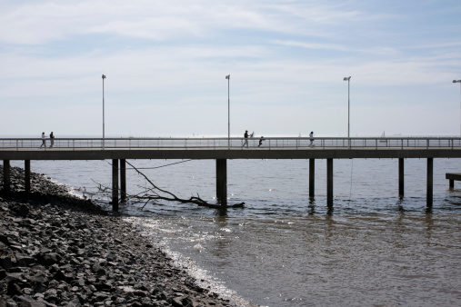 Buenos Aires, Argentina - August 19, 2013: Two people walk over the bridge on the shores of the RA-o de la Plata in Buenos Aires city.