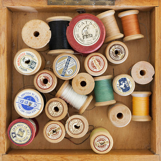 Wierden, the Netherlands - November 22, 2012 : A collection of vintage wooden thread spools in different sizes and colors in an old Dutch wooden sewing box.