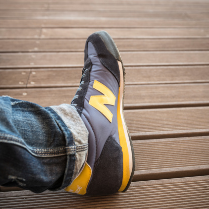 Rimini, Italy - May 26, 2013: Close up of the wearing the new balance shoes sniker model M360 on wood background. New Balance is an american footwear manufacturer based in the Brighton, new Boston.