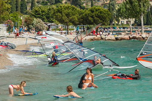 Torbole sul Garda, Italy - June 10, 2009: People enjoying a windy summer day in the northern tip of the Lake Garda, that, thanks to the constant wind, is the ideal place for windsurfing, kite surfing and sailing. Torbole sul Garda particularly is recognized as a center of international importance, and is visited every year by thousands of enthusiasts.